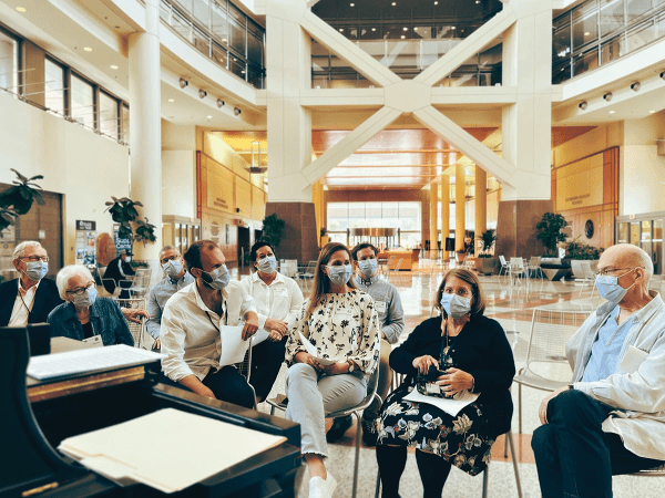 Kathy and Tim Keller (right) sitting with a group of friends for worship at NIH hospital.