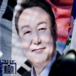 Riot police stand guard near a banner with a photo of South Korea president Yoon Suk Yeol.
